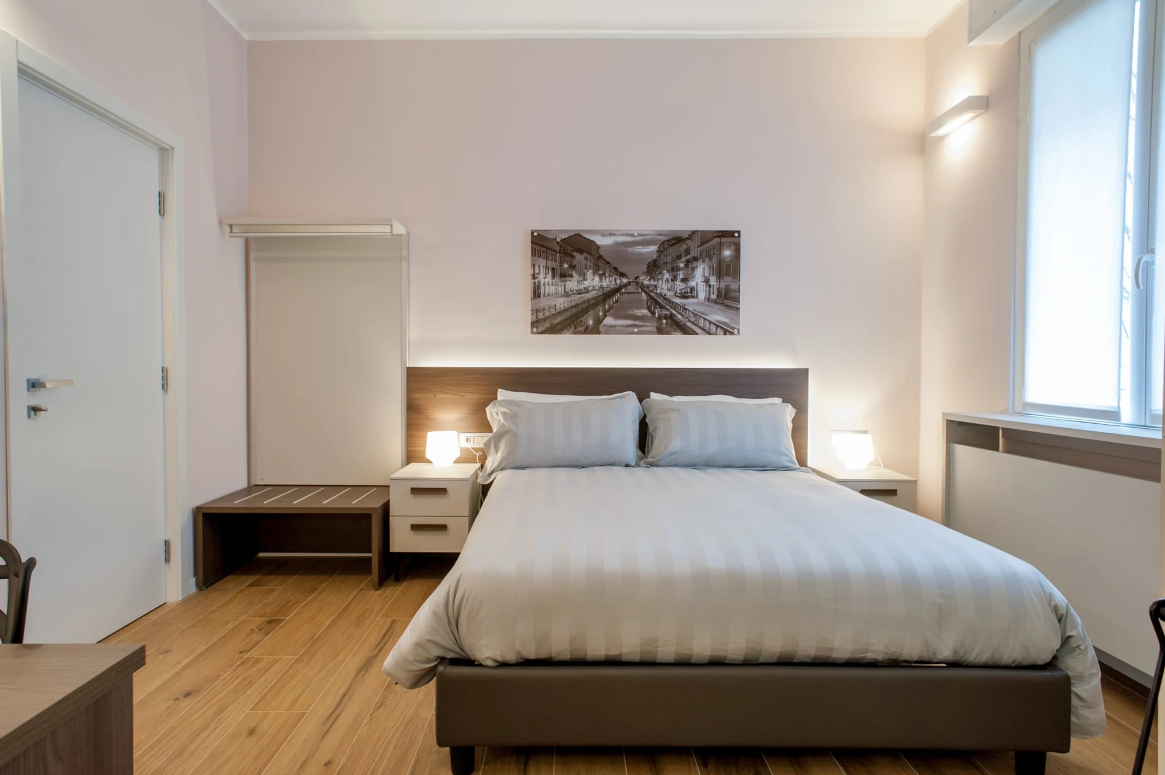 A bright, calm double room at the 2 Navigli B&B, with a sepia print of the Naviglio canal above the bed